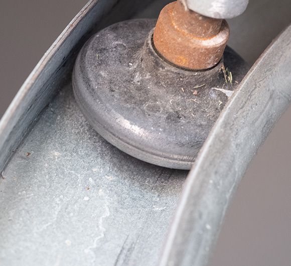 metal tool resting on a gray surface showcasing detailed textures and wear indicating possible use in maintenance or repair tasks related to five essential tools